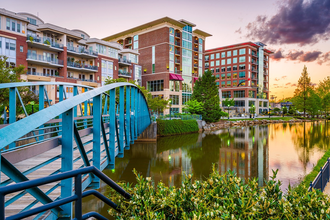 Greenville, South Carolina, USA downtown cityscape on the Reedy River at dusk.