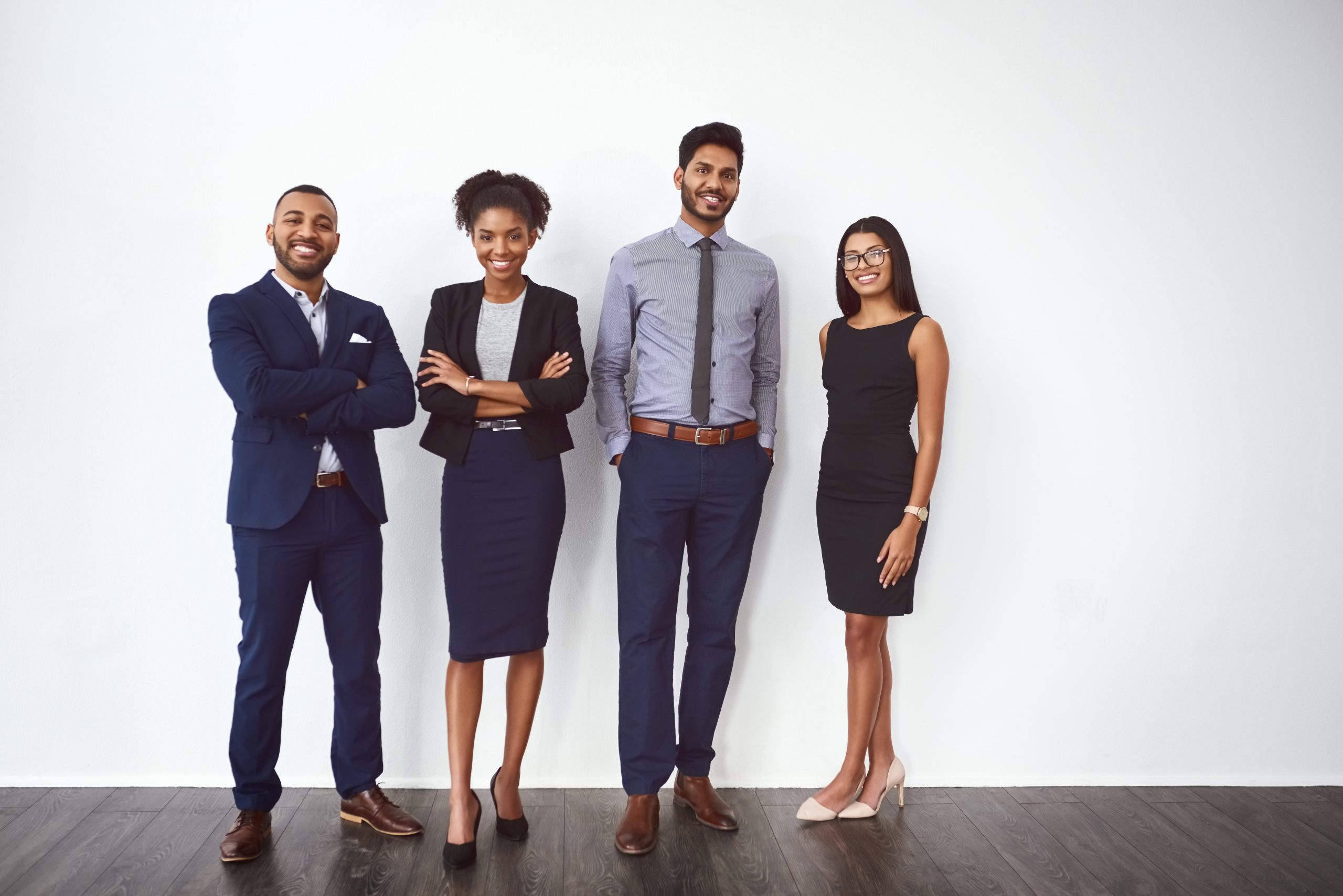 Studio portrait of a group of confident young businesspeople posing against a gray background